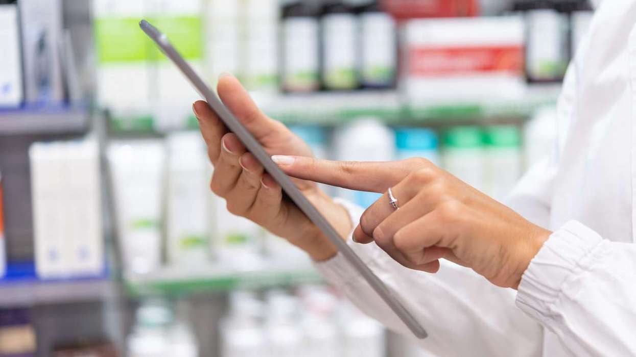 Pharmacist using digital tablet in pharmacy
